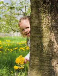 Kind hinter Baum
