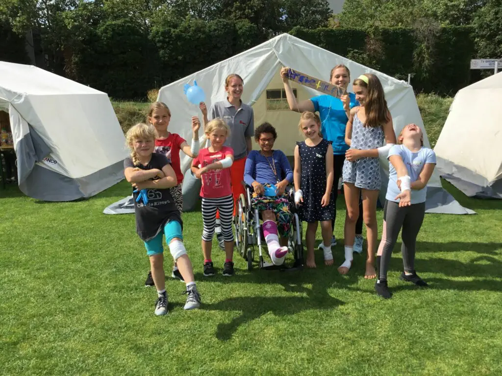 Eine Gruppe stehen vor einem Zelt, dass das Krankenhaus der Kinderstadt sein soll, bei "Bremopolis" und tragen Verbände. 