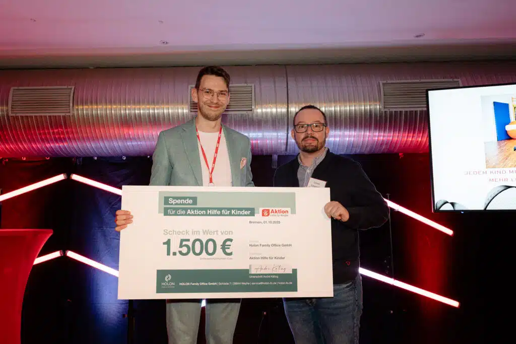 Zwei Männer halten einen Spendenscheck über 1.500 Euro für die Aktion Hilfe für Kinder.