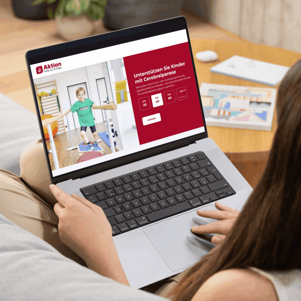 Eine Person nutzt einen Laptop mit einer Website von Aktion Luft für Kinder, auf der eine Spendenaktion für Kinder mit Cerebralparese zu sehen ist.